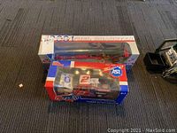 View showing two Car Quest die-cast models: Premier Supertruck with smaller car and the dragster model in packaging.