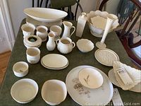 Wide view of various white Lenox porcelain bowls, dishes, and vases arranged on a table.