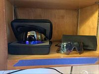 Oakley sunglasses in foam protective case alongside additional styles of sunglasses.