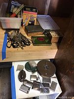 Wide view showing multiple pairs of scissors, boxes, wooden music box, and other items on a shelf.