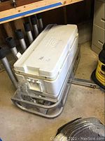 Photo showing white cooler on a metal mount with six rod holders, highlighting overall lot configuration
