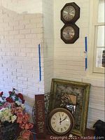 Full view of clocks, mirror, wood sign, and wood plate with hooks