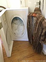 Close-up of the lace and fabric buttons of the wedding dress visible through the box window.