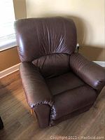 Front view of brown leatherette puffy rocking recliner chair showing cushioned back and seat.