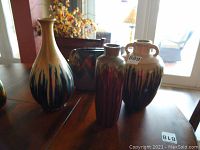Four ceramic vases from different makers including Pier 1, Stein Mart, and Three Hands Corporation, showing their sizes and glaze patterns