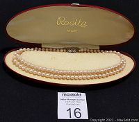 Double strand faux pearl necklace displayed inside original red velvet-lined box with 'Rosita Petite' logo on interior lid.