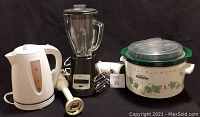 Photo showing all appliances: Rival slow cooker, Oster blender, Hamilton Beach hand mixer, electric kettle, and hand blender attachment.