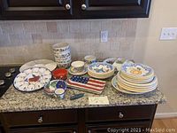 Wide view of all ceramic dishes and bowls arranged on kitchen counter, showing multiple stacks and specialty serving trays