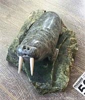 Front three-quarter view of soapstone walrus on base showing carved detail and tusks