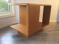 Front corner view showing open shelving compartments and pedestal base