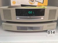 Front view of Bose Wave system main console and multi-CD unit stacked, clock reads 10:21