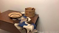 Photo of the round basket, oval basket, and table runner arranged on a wooden surface.