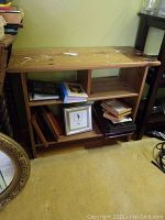Photo showing wooden shelf with paint spatters on top and scratches, with items on shelf for scale but not included.