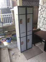 Front view of steel metal locker with four compartments, showing recessed handles and black detailing.