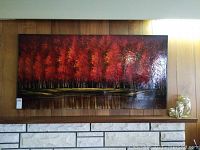 Full frontal view of the large signed canvas painting showing autumn trees with vibrant red leaves, water reflection, and glossy finish.