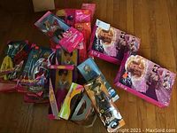 Photo of multiple Barbie and Ken dolls in original packaging showing assortment including Valentines Barbie, Oreo Barbie, French Barbie, and Twinkle Lights Barbie. Some boxes slightly dented.