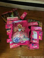 Photo of boxed Birthday Barbie surrounded by other packaged dolls including Graduation Barbie boxes
