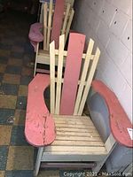Photo showing two Adirondack chairs positioned in a basement against a white block wall, showing overall condition and design.