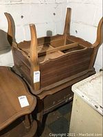 Two matching vintage wooden tables upside down showing the underside and structural details, mildew present
