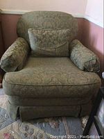 Front view of Morgan Stewart armchair with matching throw pillow showing green floral damask upholstery.