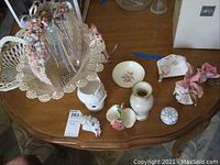 Overview photo of ceramic and fabric baskets, figurines, vase, candle holder, dish and flower bowl on wooden table