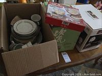 Box containing assorted china classic dishes including plates and cups