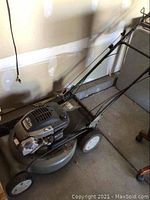 Side angle of Craftsman lawn mower showing deck, engine, wheels, and handle.