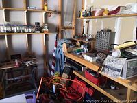 Corner of garage showing wooden shelves, workbench and assorted items