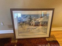 Framed print leaning against a wall on carpet showing full view