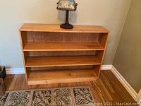 Front view of the oak bookcase showing overall shape, wood grain, and three shelves.