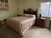Full view of queen bed, headboard, nightstands, and partial dresser