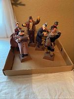 Six figurines arranged in cardboard box, overview of entire lot