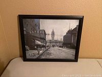 Framed photo print of Union Station 1894 displayed leaning against a beige wall on a table.