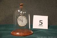 Silverode Rockford pocket watch displayed inside a glass bell jar with wooden base and finial, next to a lot number card.
