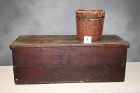 Side view of primitive blanket chest with wooden bucket placed on top, showing size and color.