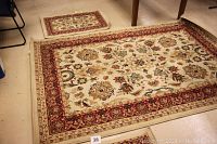 Photo of the large Oriental rug and one small matching throw rug laid on floor showing color, design and size relation