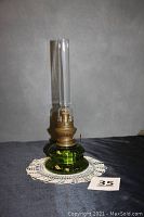 Full view of the green Kosmos kerosene lamp showing overall shape and clear chimney.