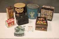 Group photo of 9 eclectic vintage tins showing overall shapes and designs including syrups and pretzels