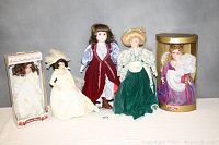 Photo of all five collectible dolls, four in original boxes, arranged side by side showing size and outfit detail