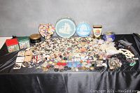 Wide view of large quantity of buttons in multiple tins and containers