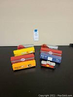 Top view of eight HO gauge freight train cars arranged on a black surface, showing Planters, SP, Chessie System, and other logos.