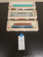 Three boxed HO scale freight train cars stacked vertically on a dark surface. Boxes show vintage Bachmann branding.