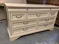 Six-drawer dresser front view showing decorative handles and almond paint finish