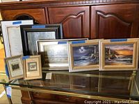 Set of framed wall art and decorative framed prints on glass table