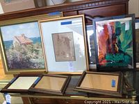 Wide shot of various framed art including Monet print, small framed artworks, Blade Runner poster, small frames on stand