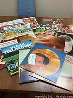 Overview of multiple vintage country music vinyl LP records arranged on table showing album covers and artist titles.