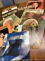 Photo showing a collection of 8 vintage LP record albums overlapping including Billy Joel, Lynn Anderson, Tammy Wynette, Hank Williams