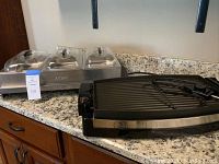 Photo showing Wolfgang Puck reversible grill and Aroma buffet server with three warming compartments with clear lids on kitchen counter