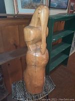 Side view of the wooden paddlebill bird carving showing natural wood cracks and putty repair.