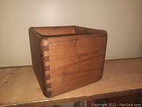 View of the pine box showing dovetail joints and finish on wooden surface